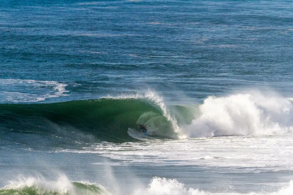 Surfer in the barrel at one of the most dangerous waves in the world called Cave